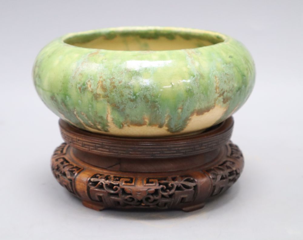 A Chinese green and straw-coloured crackle glaze brushwasher, Qing dynasty hongmu stand, height 13cm overall